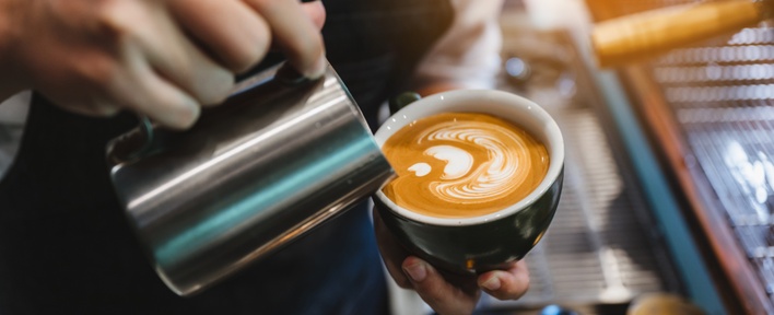 Hier zie je een vers gemaakt kopje koffie met latte art